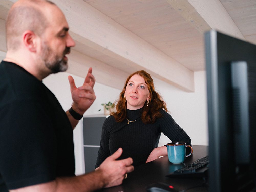 Besprechung zwischen einem Mann und einer Frau im Büro am Schreibtisch